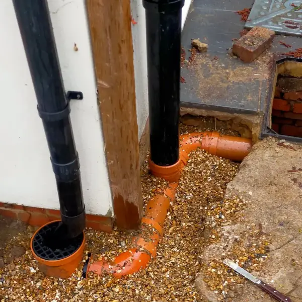 Gully trap installation under way, new orange drain fittings beside the inspection chamber