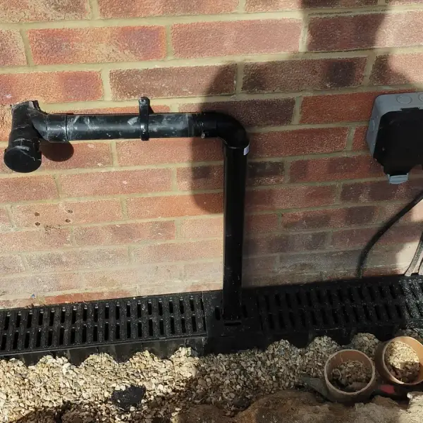 New ACO channel drain laid along a house wall