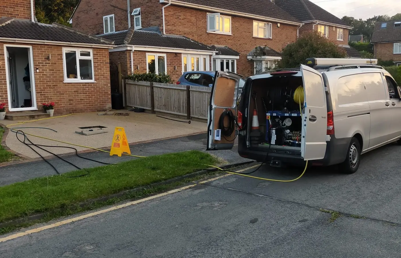 Vision Plumbing van on a driveway with the jetting hose run to a blocked drain